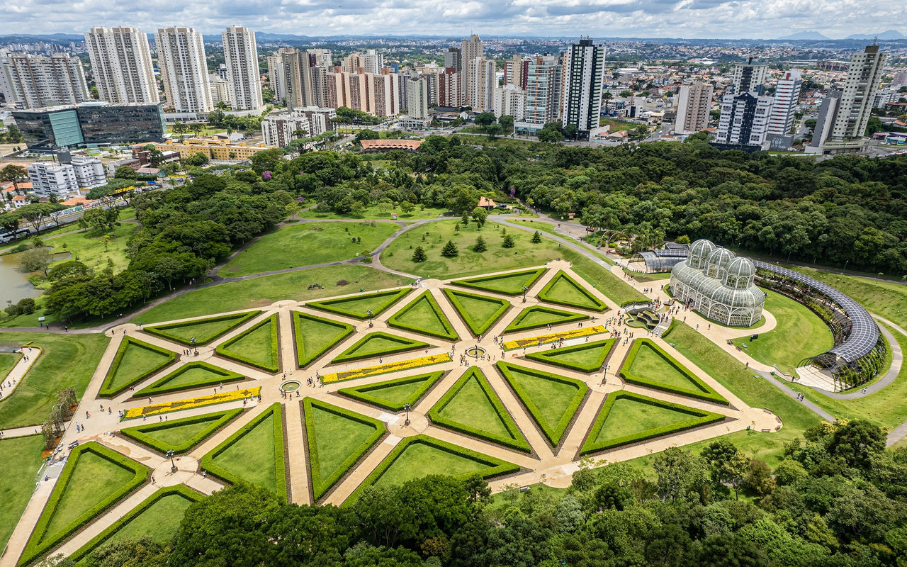 Vista aérea de Curitiba con parques verdes exuberantes y arquitectura moderna e imponente.