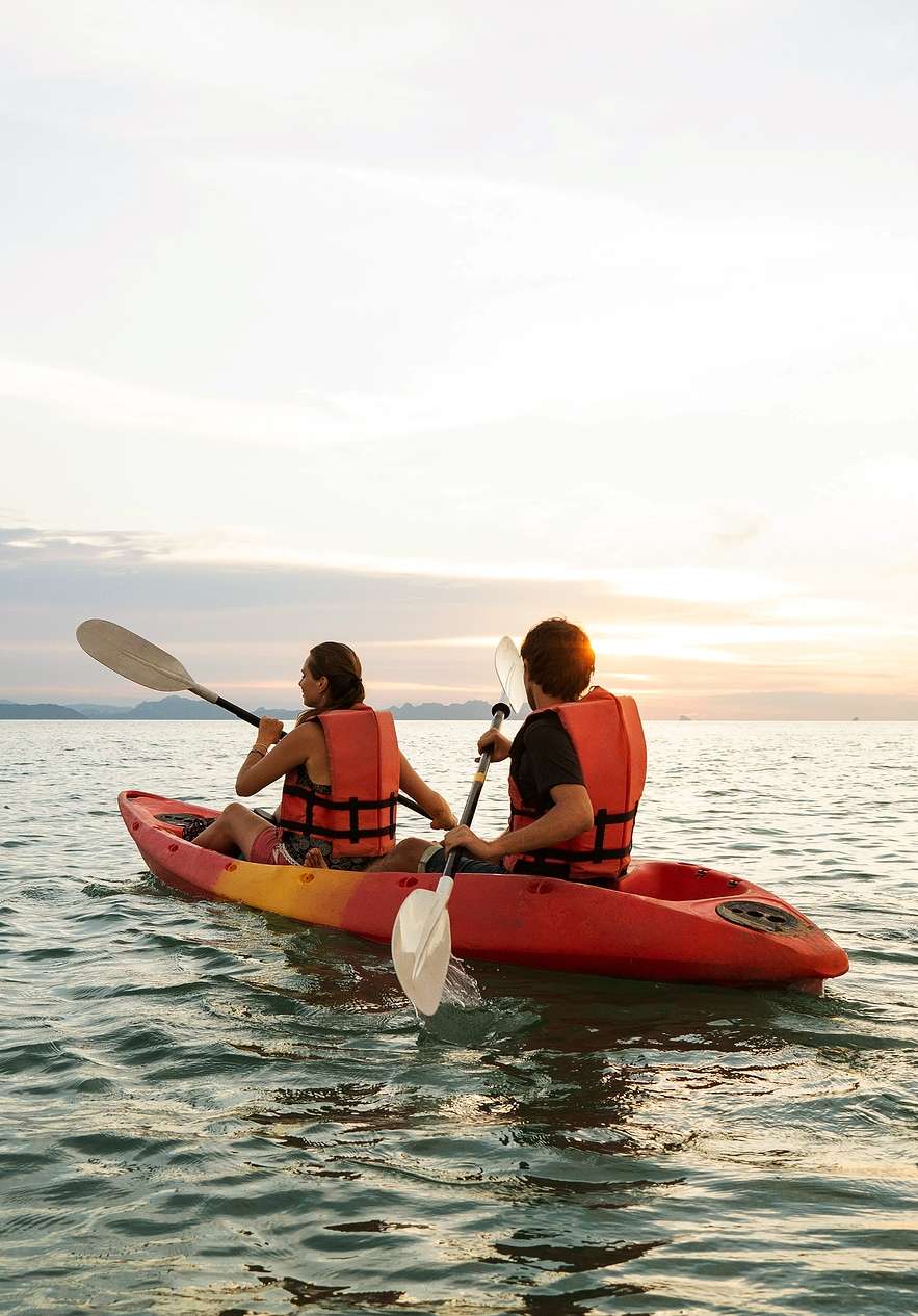 Duas pessoas a remar dentro de um kayak no mar calmo da Comporta