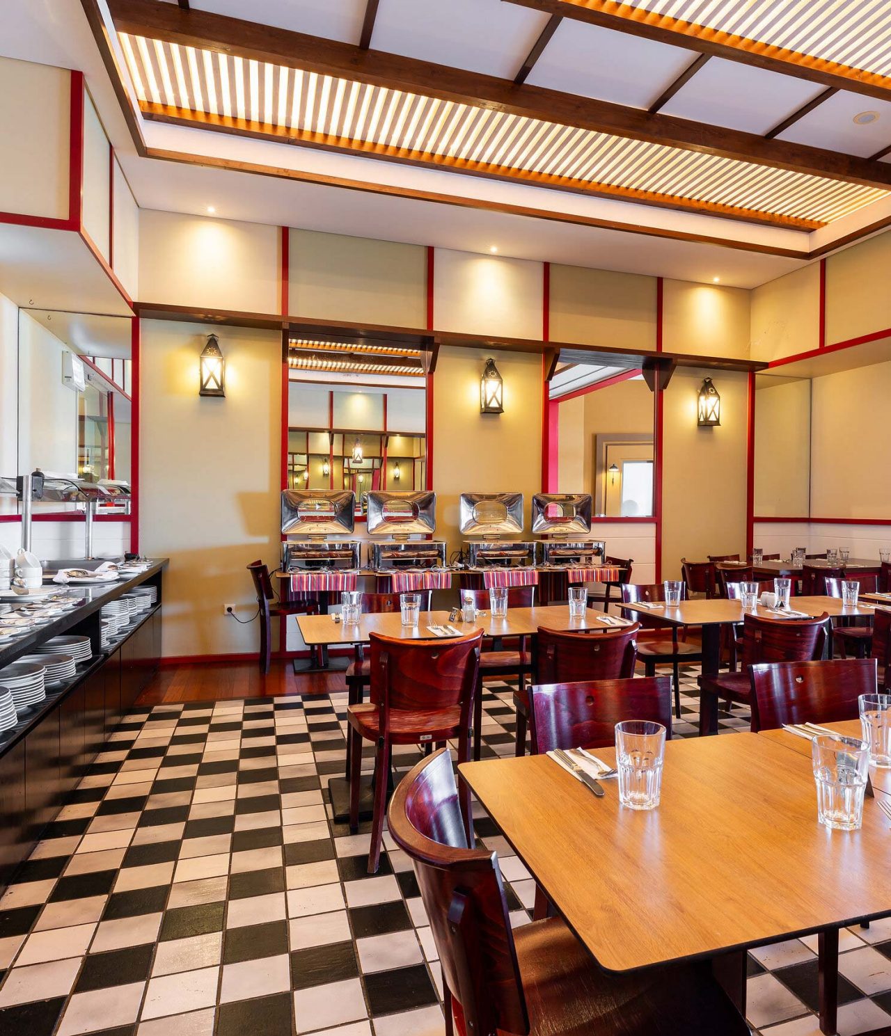 O restaurante Luigi, do Resort de 5 Estrelas no Porto Santo tem mesas e cadeiras escuras e apontamentos em vermelho