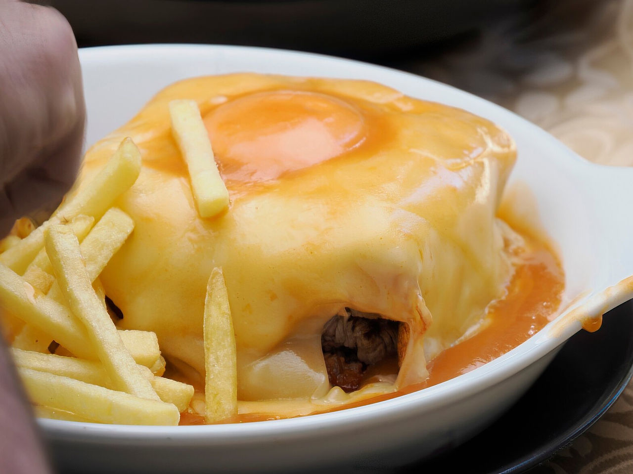 Típica francesinha à modo do porto, famosa pela sua combinação de enchidos, pão, carne e molho especial