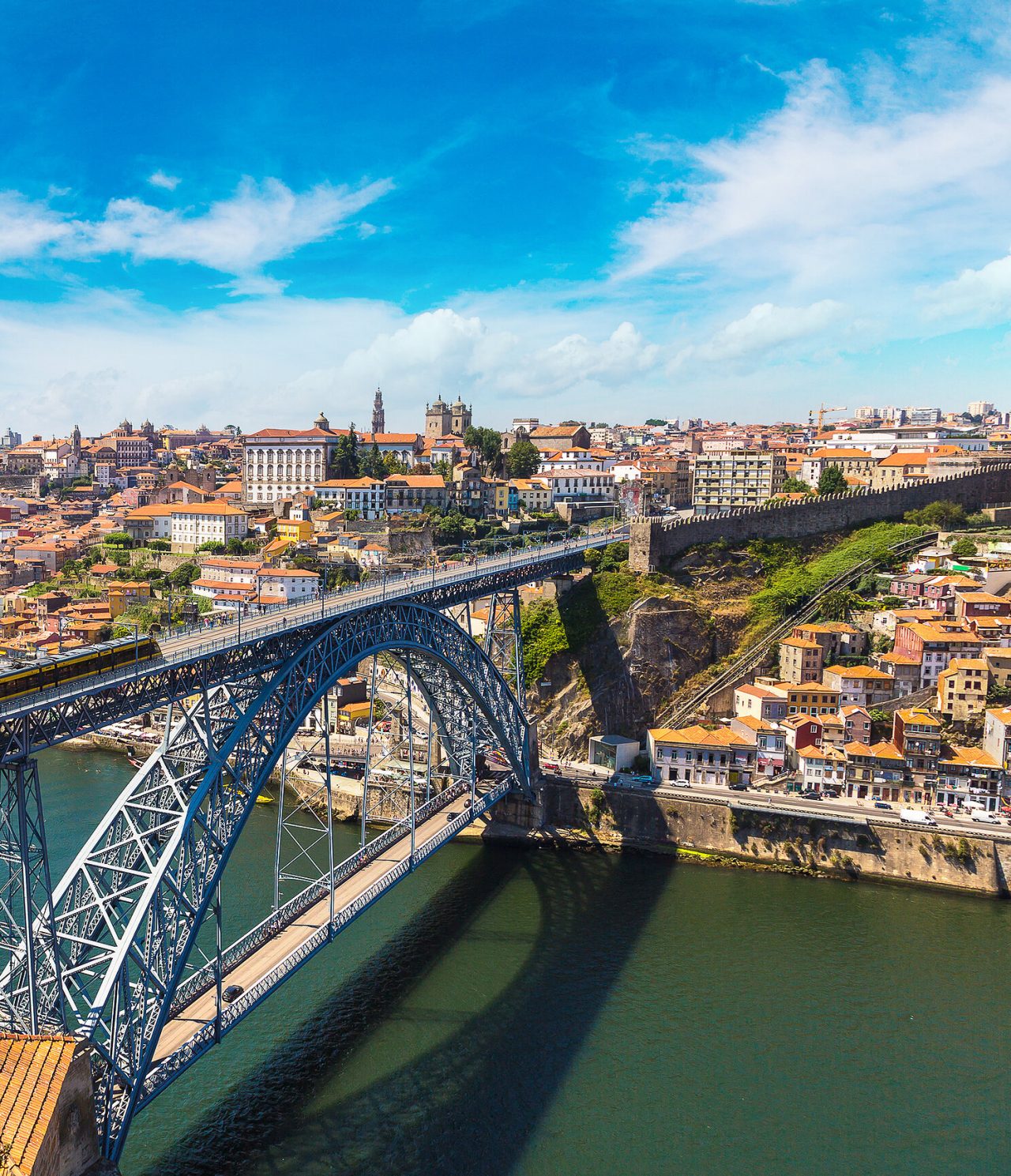 Vista aérea da Ponte Dom Luís I, sob o rio Douro, com a cidade do Porto por trás, com os seus edifícios históricos