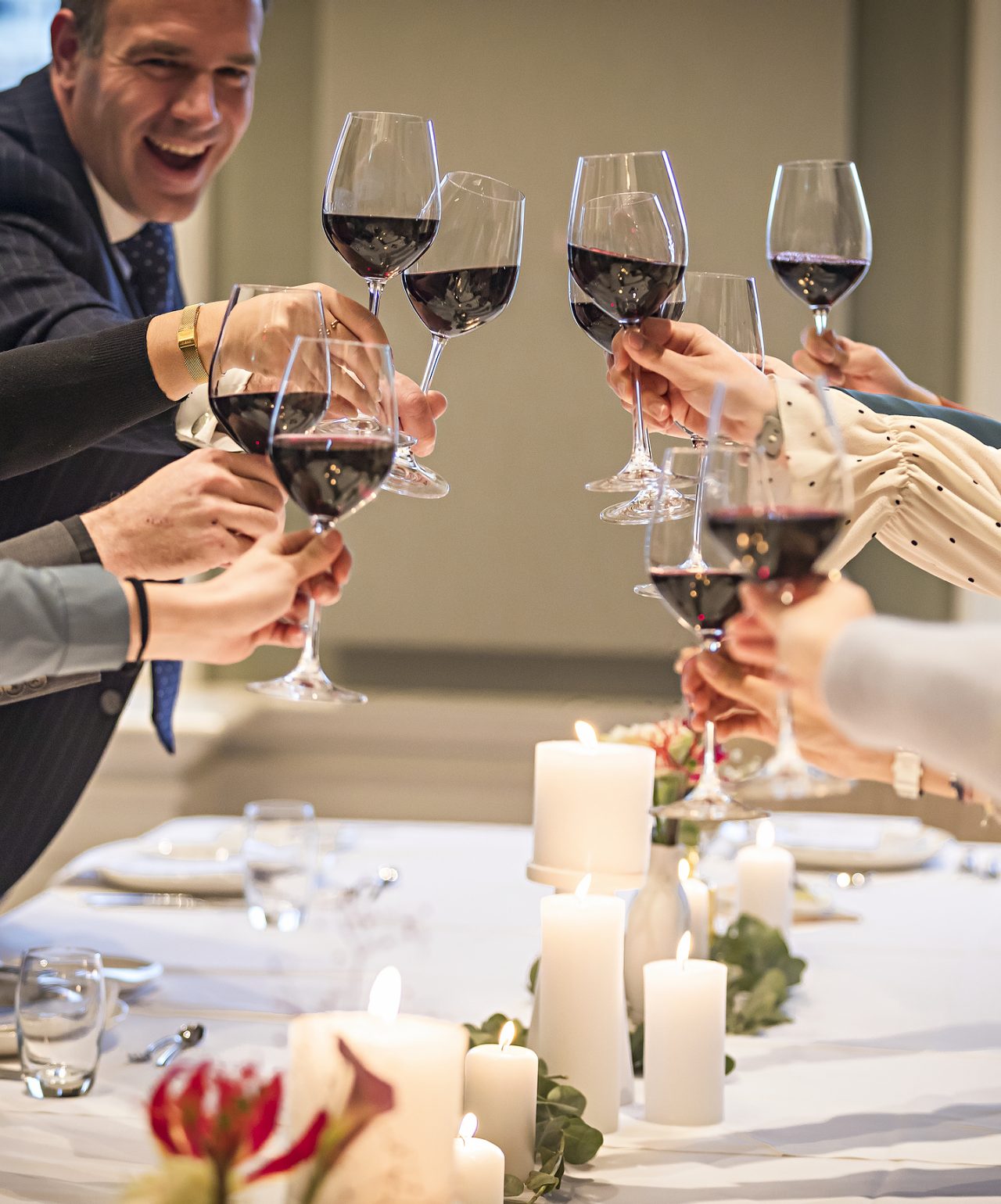 Convidados brindam com copos de vinho tinto em casamento com decoração elegante no Pestana Hotel Group