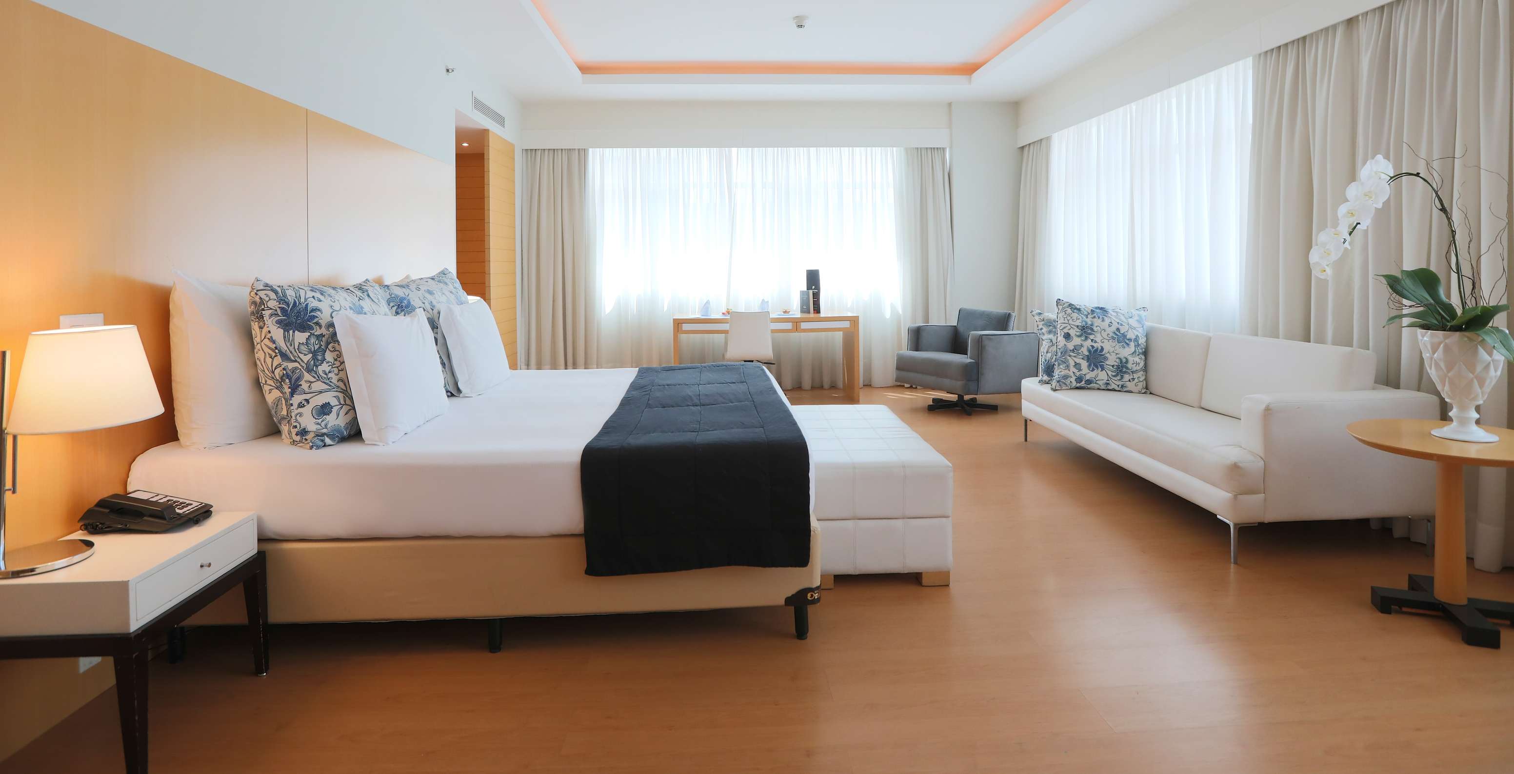 The Executive Suite at Pestana Curitiba is spacious and bright, with a king-size bed, sofa, and a desk