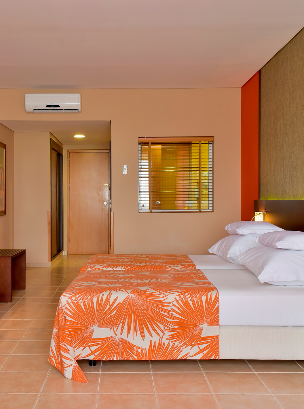 The Standard room at Pestana Tropico features two single beds, television, bedside table, mirror, and a chair