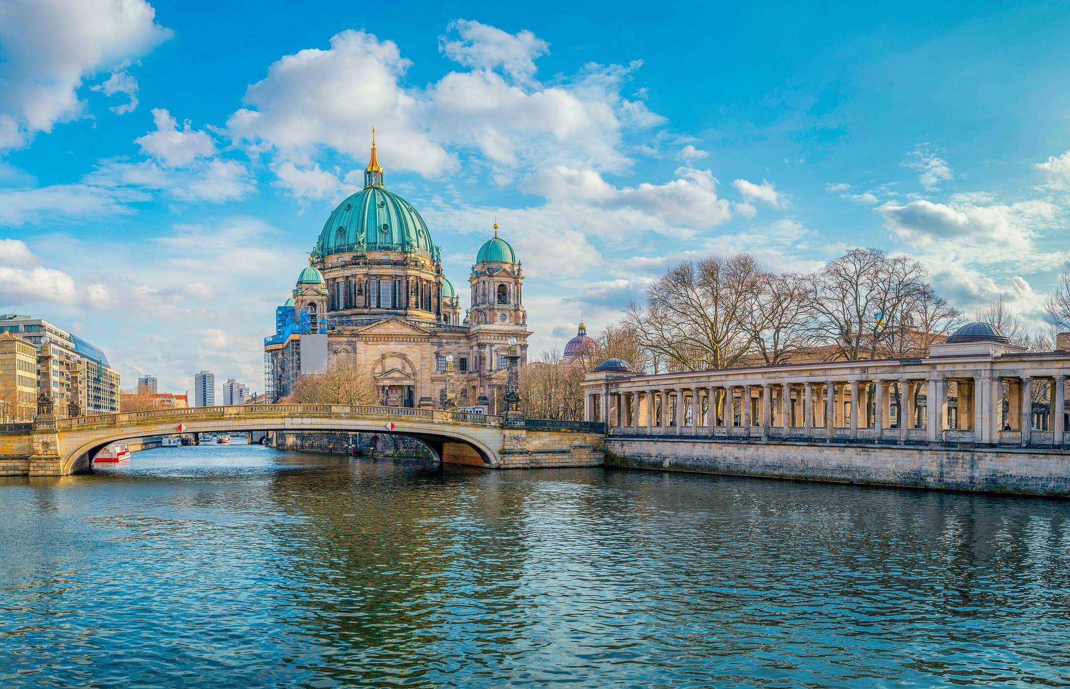 View of the famous Berlin Cathedral, with a pedestrian bridge in front, and the river flowing underneath