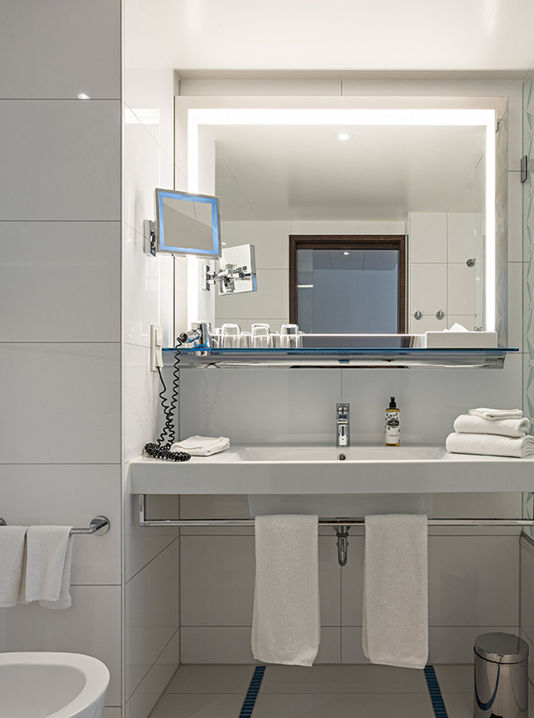 Deluxe room at Pestana Berlin Tiergarten has a bathroom with bathtub and shower, a sink, and a mirror