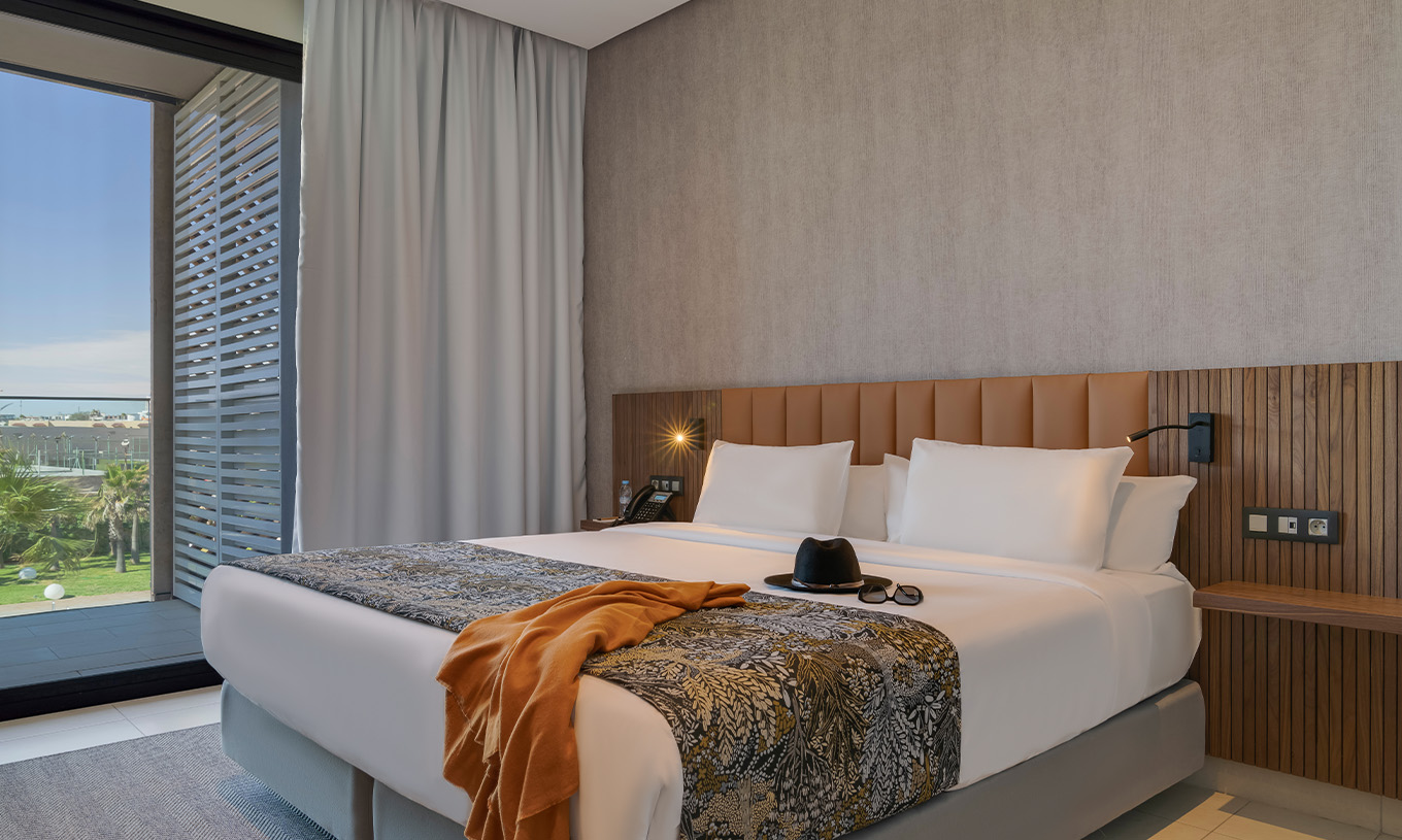 The Premium Superior Suite at Pestana Casablanca has a bedroom with a double bed and a balcony beside it