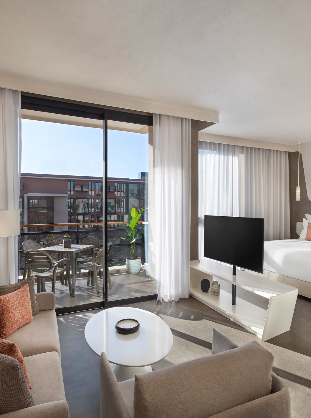 The CR7 Junior Suite Avenue at Pestana CR7 Marrakech has a seating area with sofas and TV, and a balcony with a table