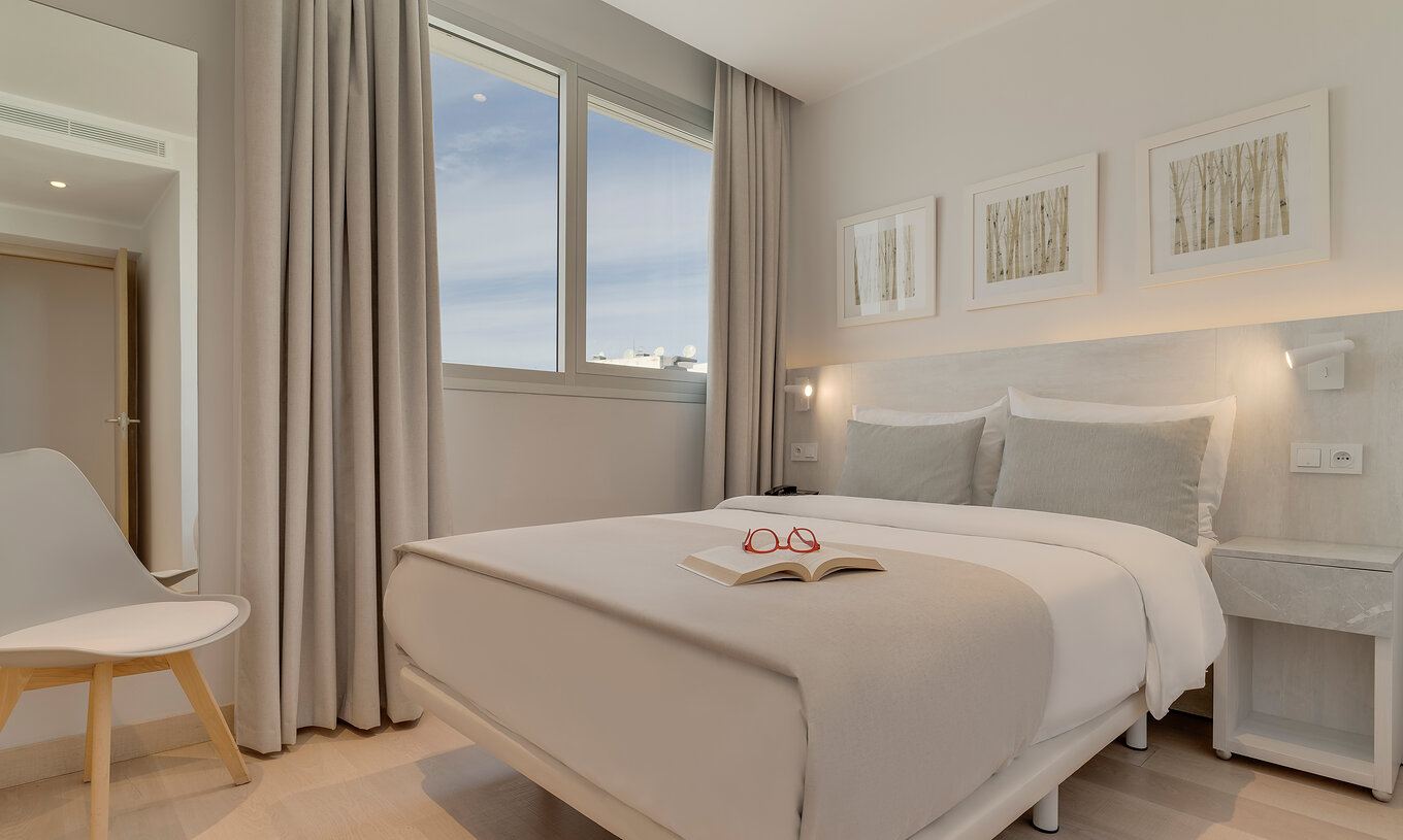 The Family Suite of Pestana Tanger City Center features a double bed with stone headboard, a window, and a chair