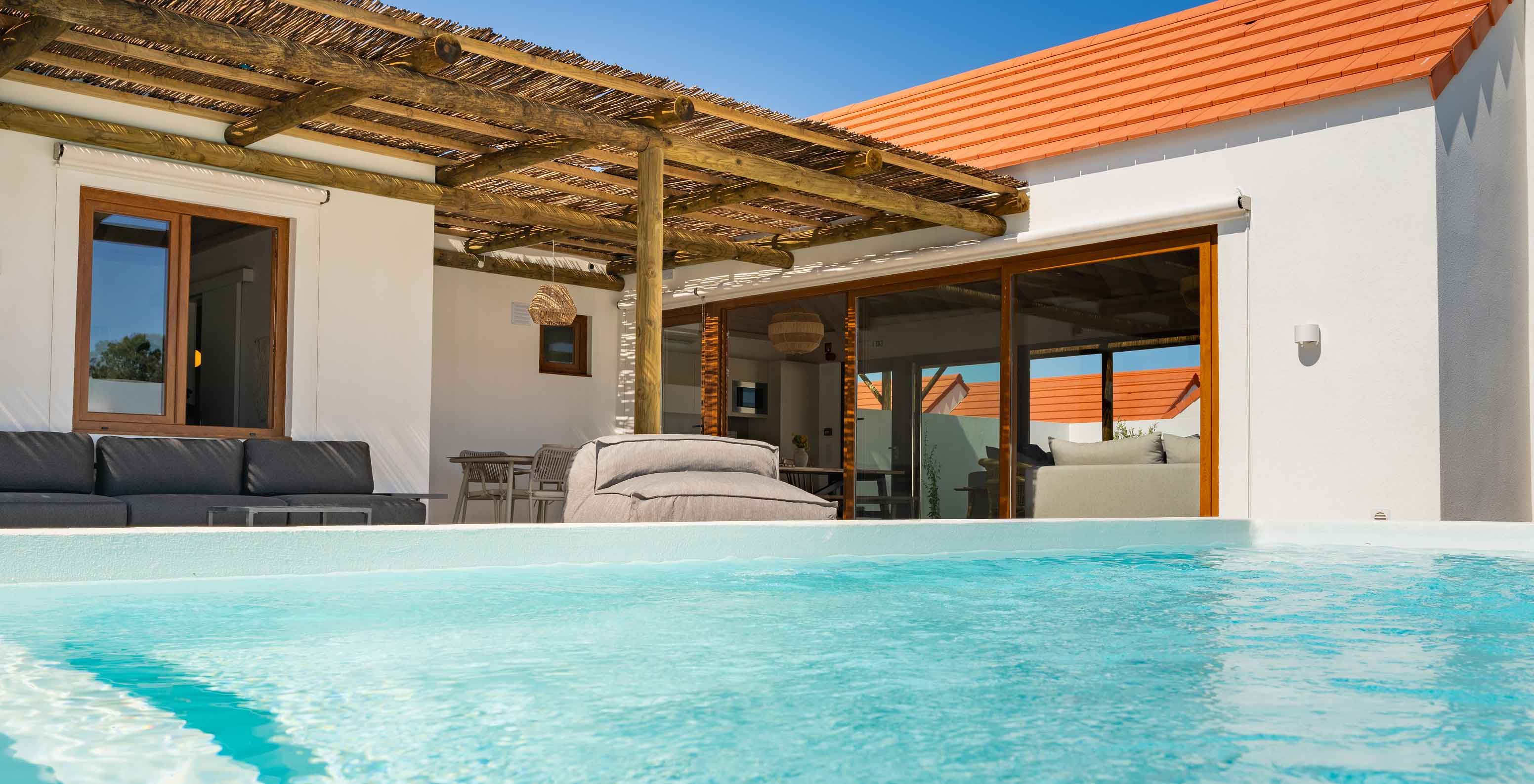 The Premium Green Villa at Pestana Comporta Village Residences has an outdoor pool area with sofas and a table