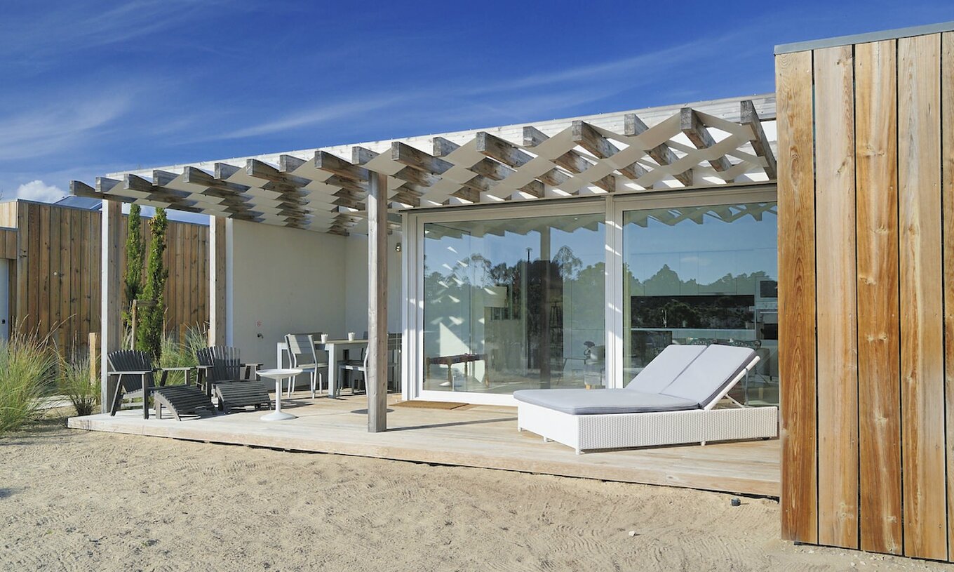 The Green T3 Villa of Pestana Tróia Eco Resort has a terrace with sun loungers, table, and chairs