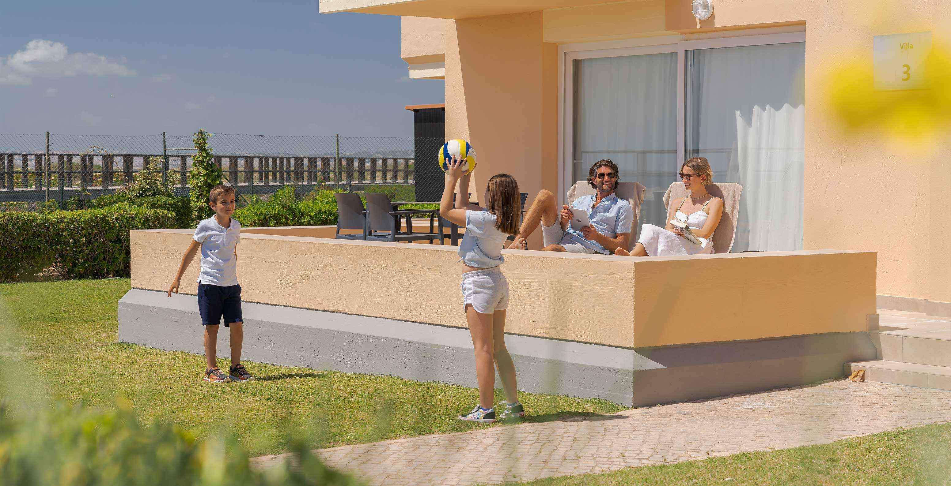 Family relaxes in their villa, enjoying sea and boardwalk views to Alvor Beach