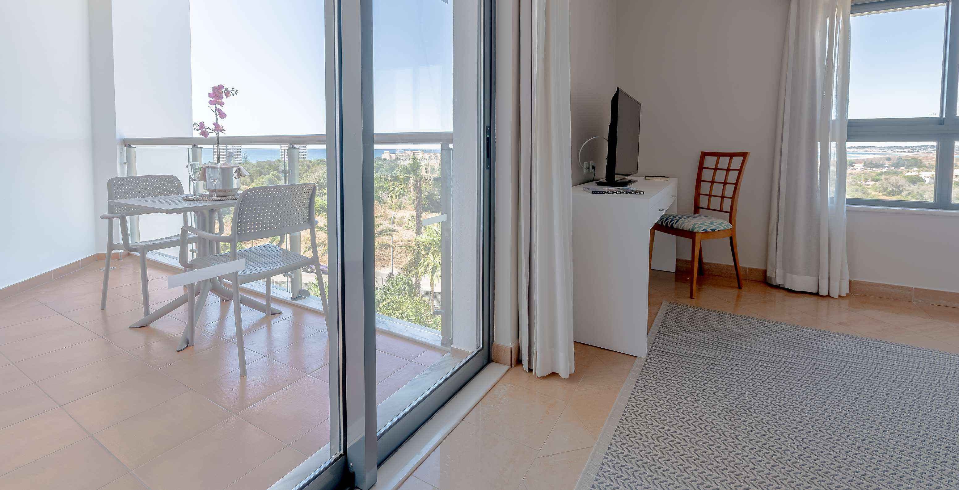 The T0 - Studio at Pestana Alvor Park has a balcony with a garden view and the sea in the background, with a table and chairs