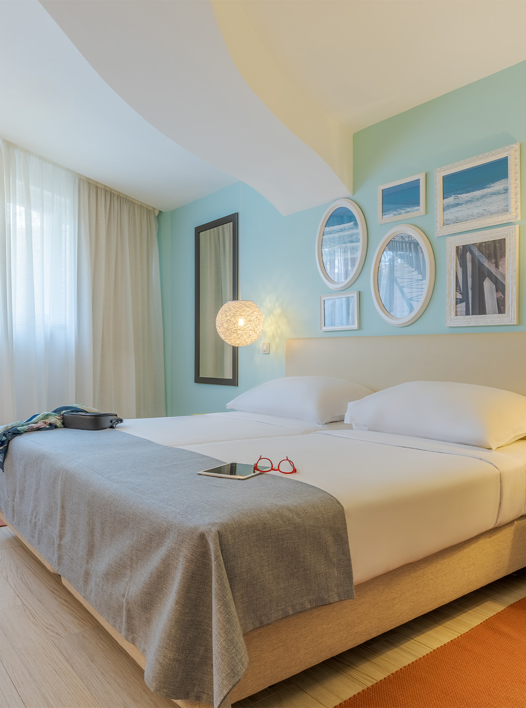The Duplex Sea View Suite T1 at Pestana Alvor Praia has two joined beds, a bedside table, rug, and art