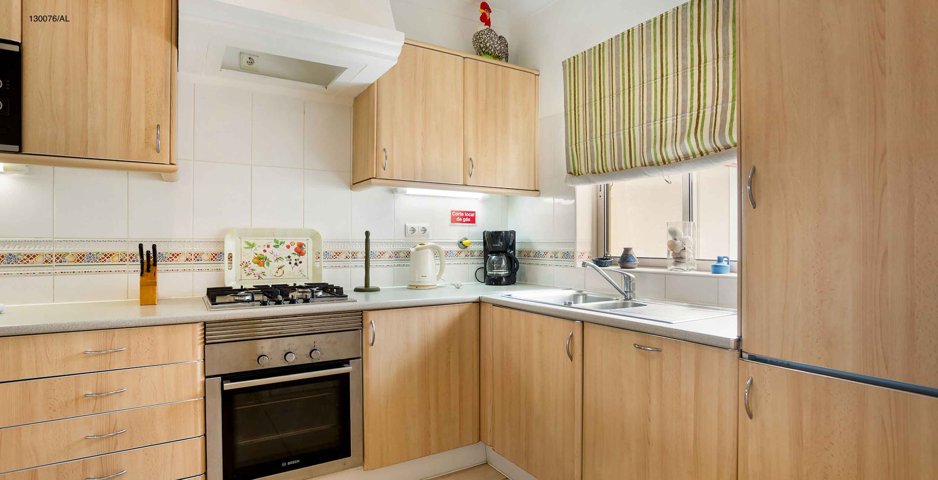 The Pestana Carvoeiro Golf T2 Standard Apartment has a kitchen equipped with wooden cabinets and appliances