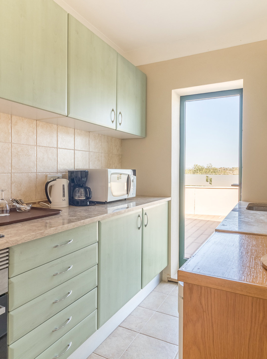 The studio at Pestana Gramacho Residences has a modern kitchen with appliances and access to the balcony