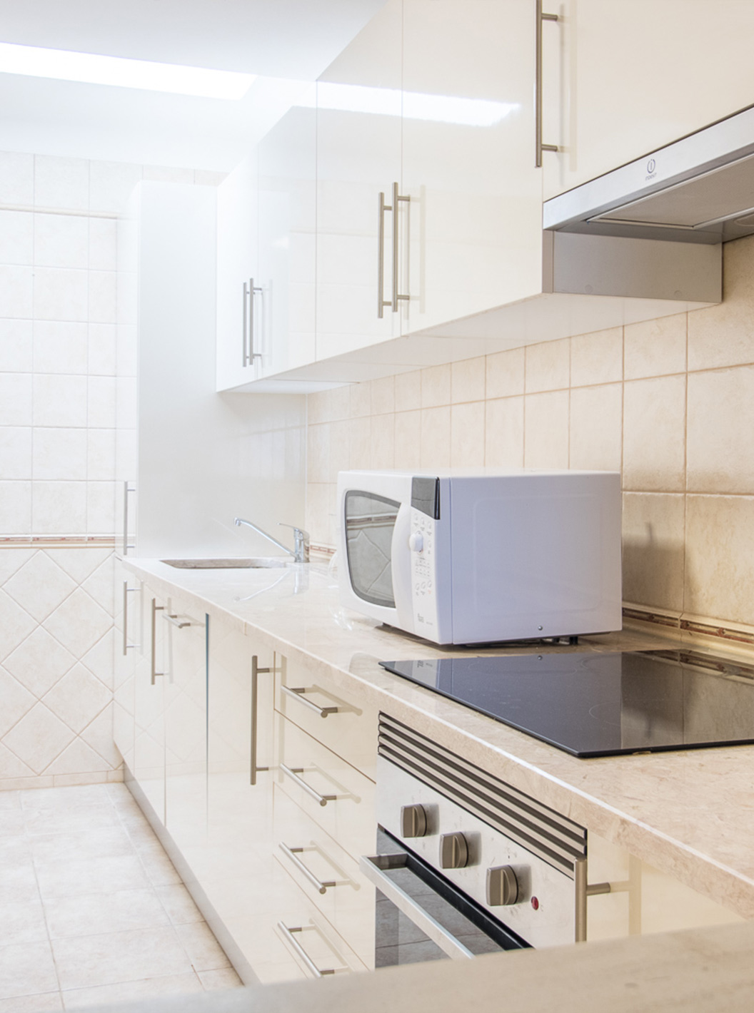 The one-bedroom apartment at Pestana Gramacho has a simple kitchen with appliances and neutral decor