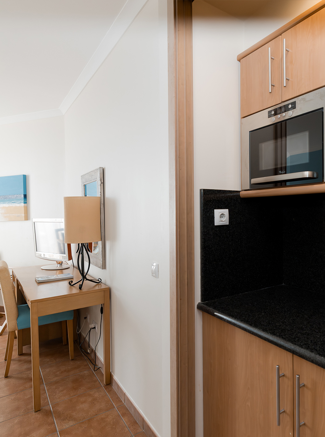 The Deluxe at Pestana Viking has a desk and a small kitchen with microwave and several cabinets
