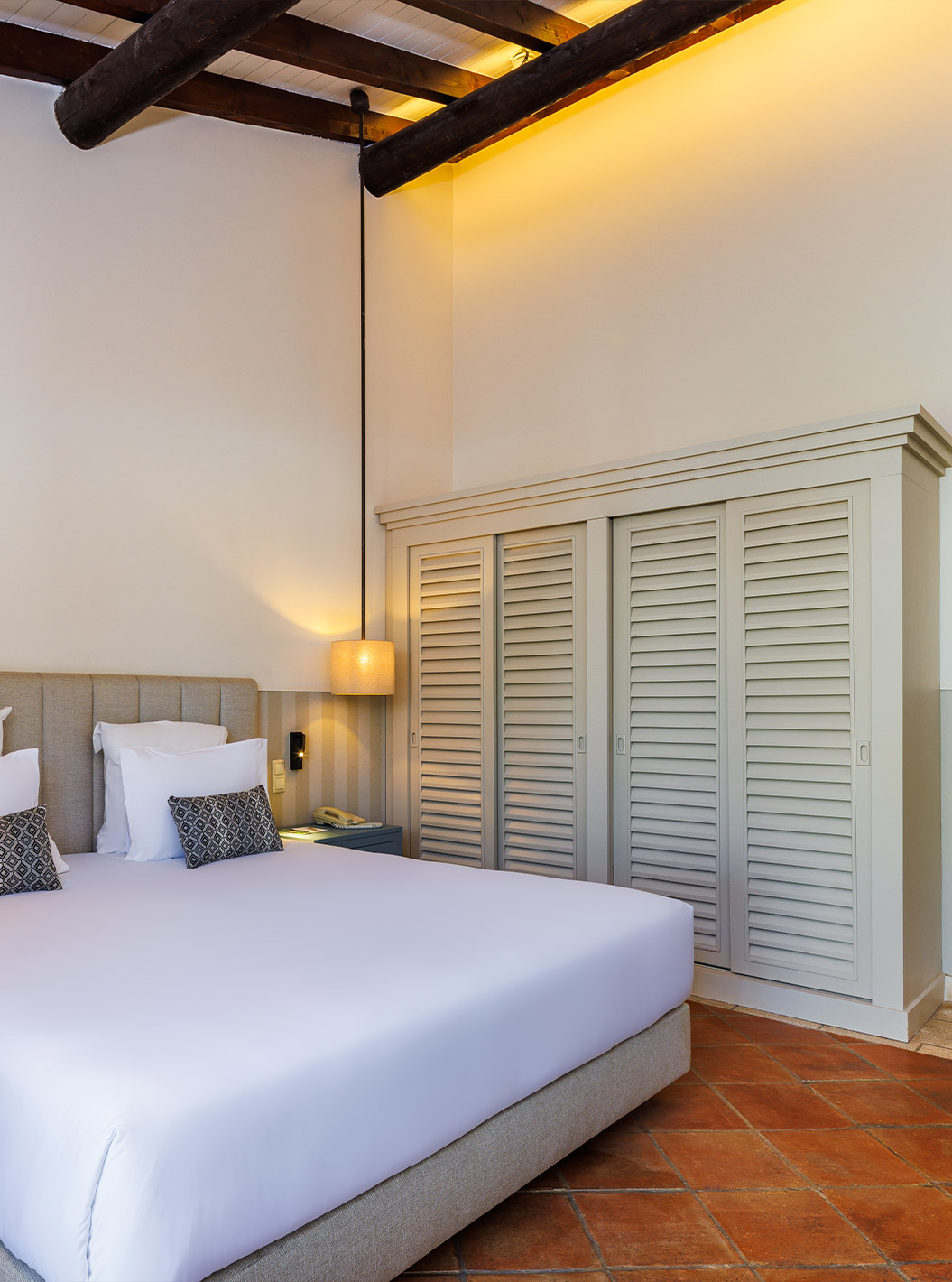 The Family Garden View at Pestana Vila Sol - Vilamoura has a double bed with two nightstands and a large wardrobe