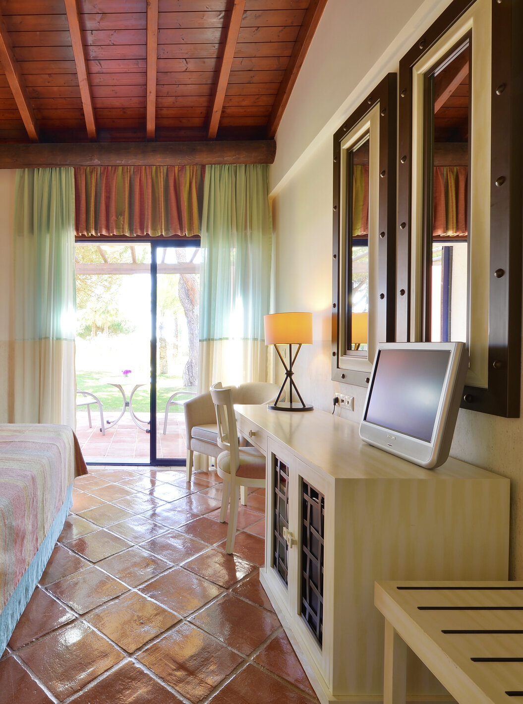 The Garden View Suite at Pestana Vila Sol - Vilamoura has a bedroom with a double bed, mirrors, and a window with a balcony