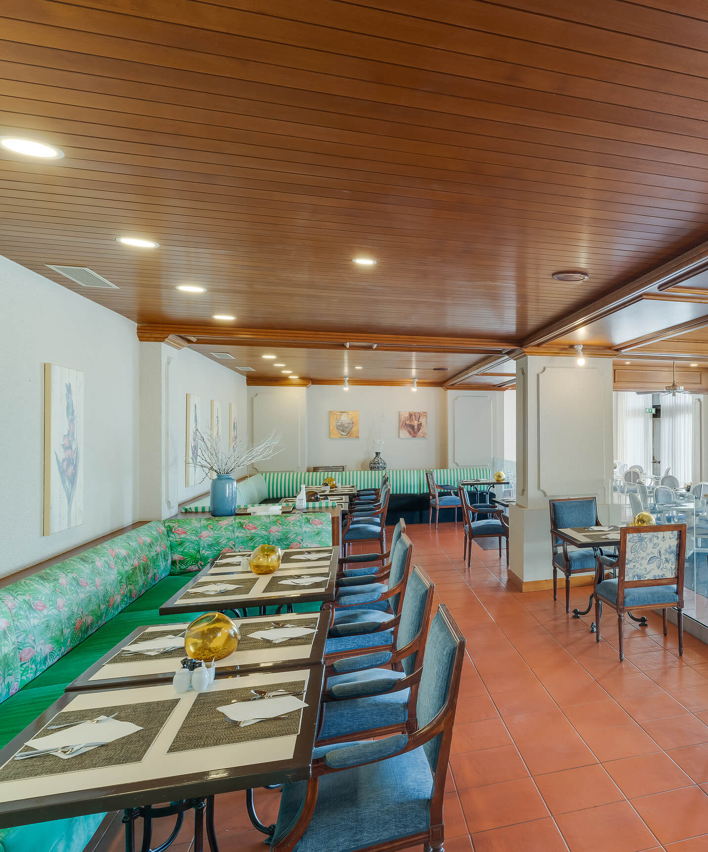Casual dining area at Pestana Bahia Praia with decorated tables and green benches along the wall
