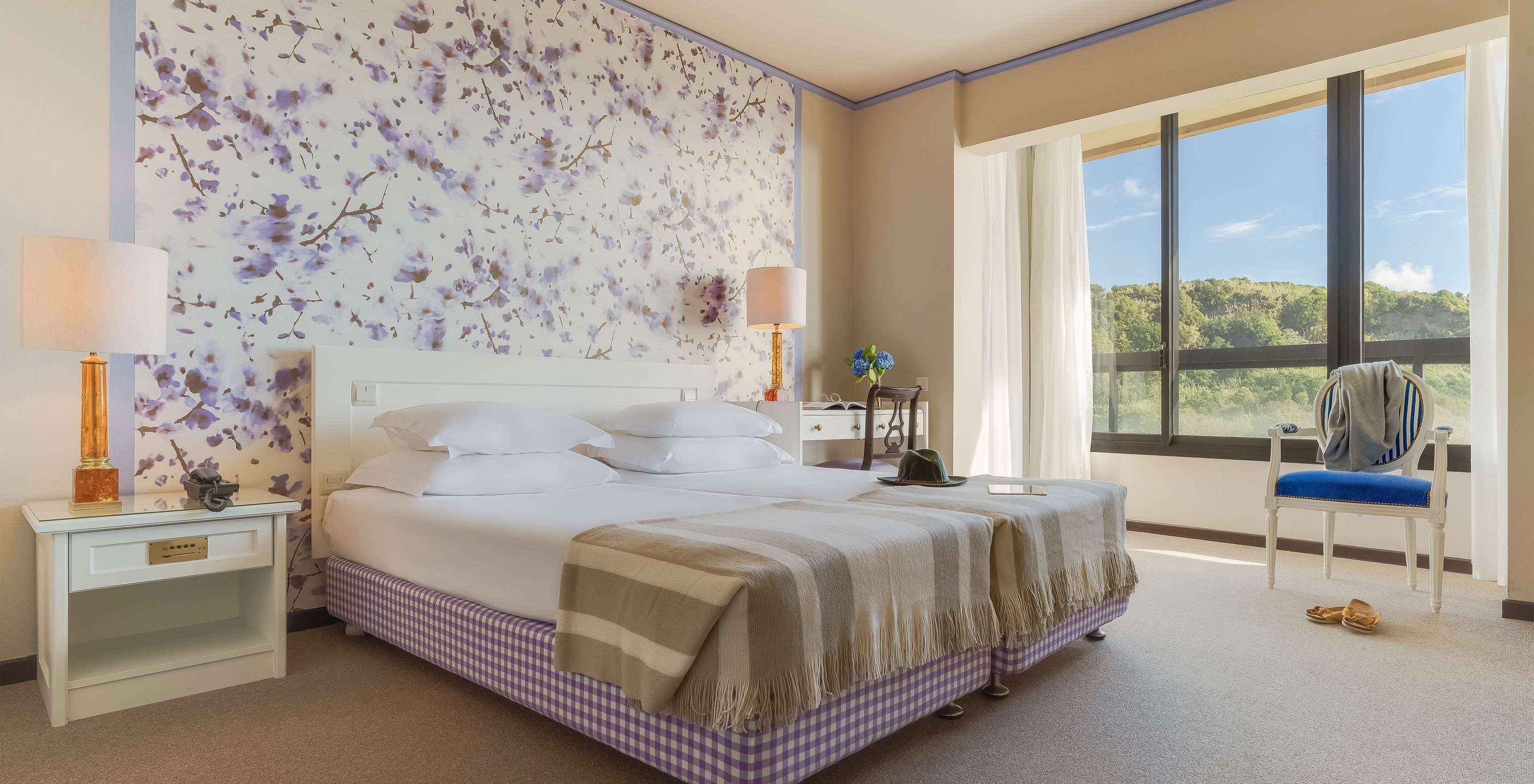 Standard Garden View room at Pestana Bahia Praia is a spacious room with two beds, a bedside table and a desk