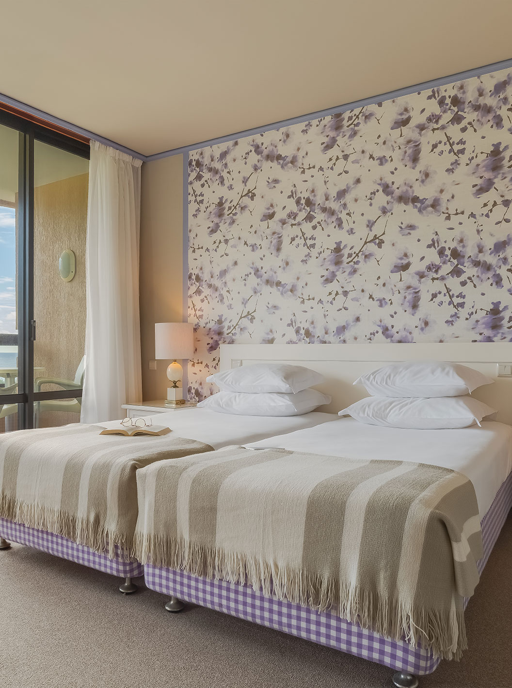 In Junior Garden View Suite at Pestana Bahia Praia, beds are next to the balcony, with views of gardens and sea