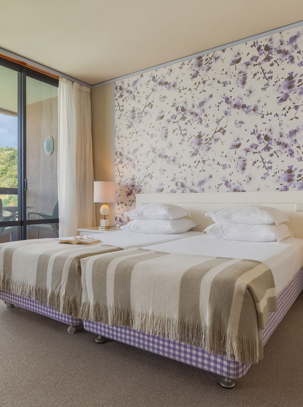 In Junior Sea View Suite at Pestana Bahia Praia, beds are next to the balcony, with views of gardens and sea