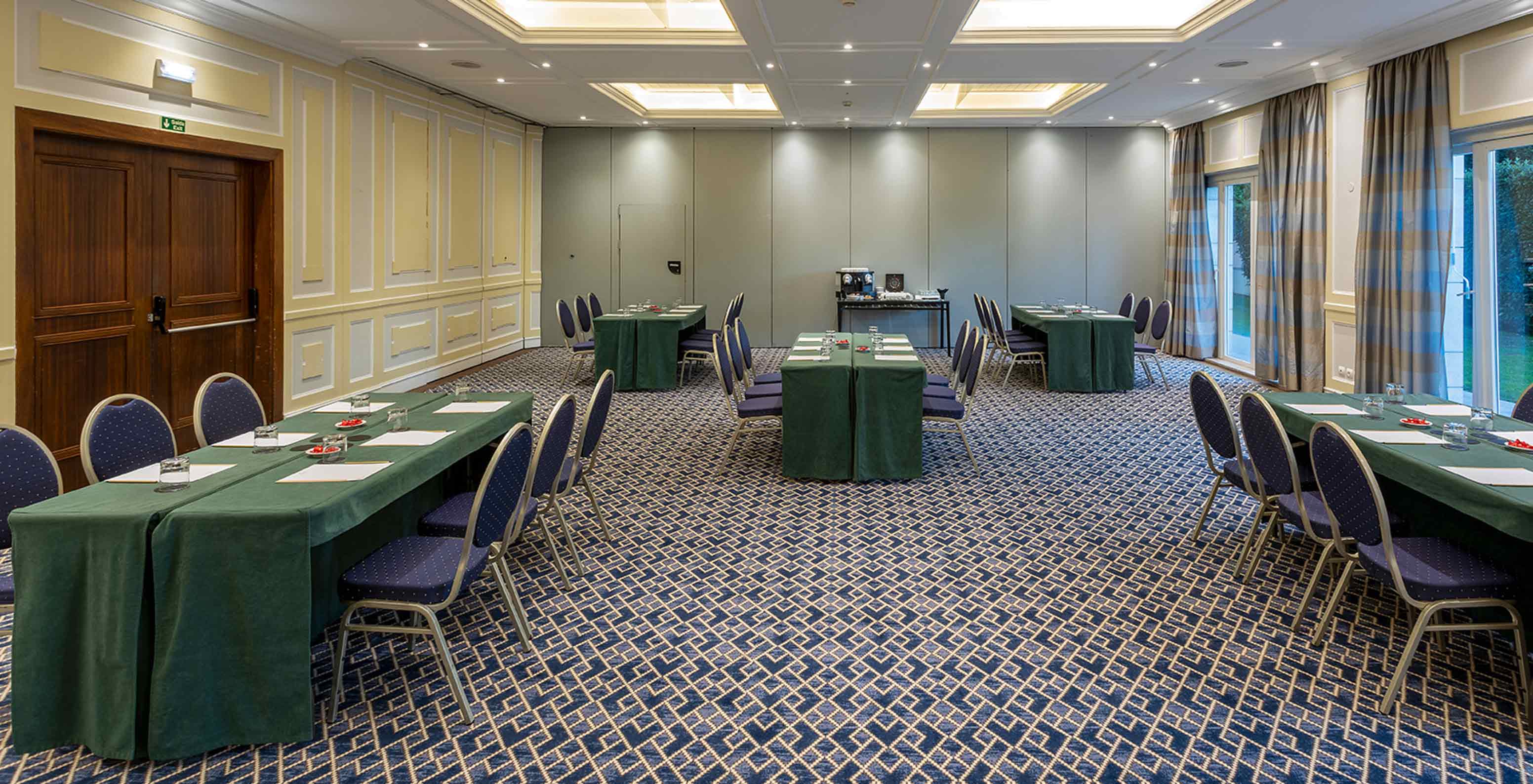 Pestana Palace Lisboa has a meeting room with blue carpet, large windows and long grey curtains