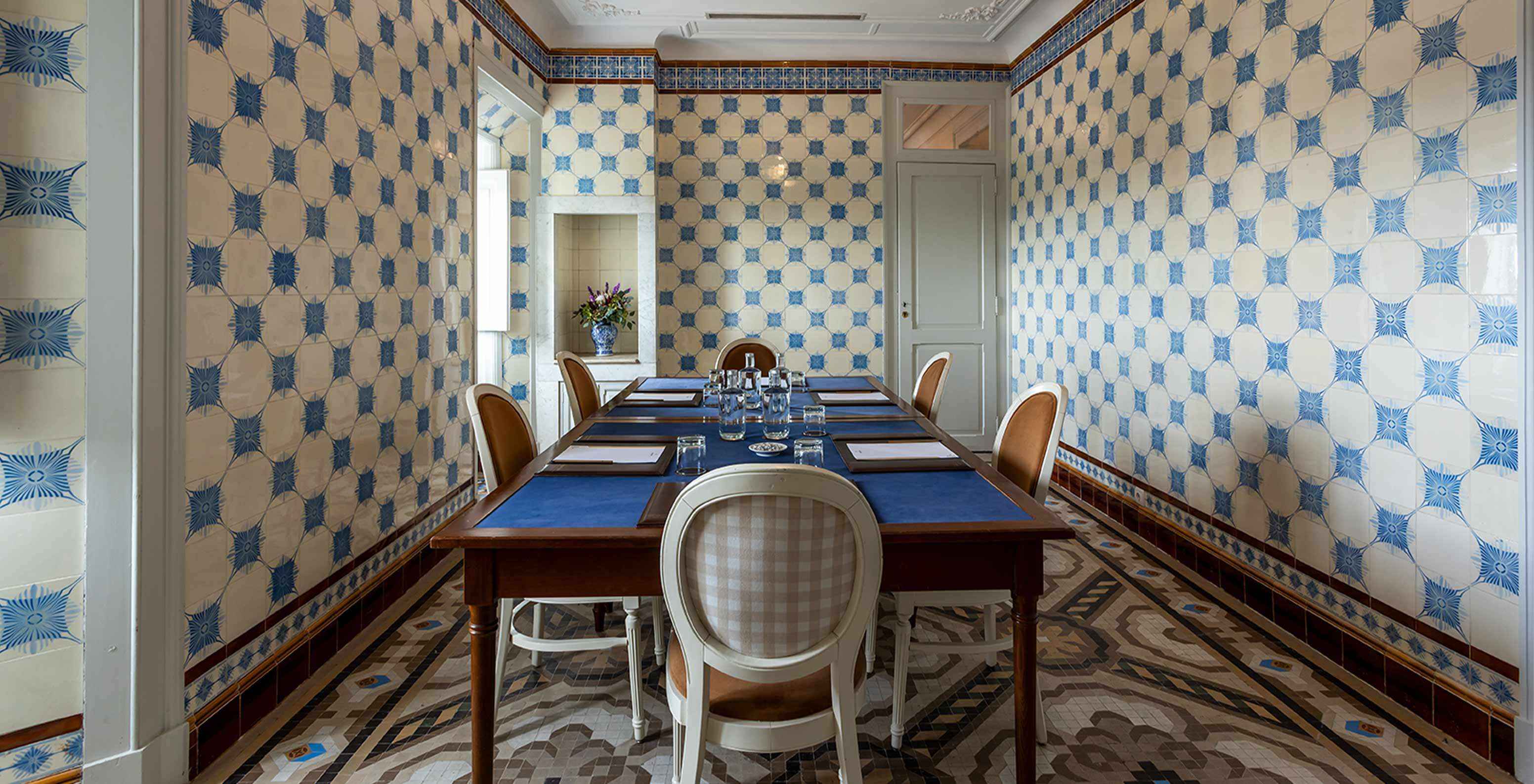 Pestana Palace Lisboa has a meeting room with blue and white tiles and a table surrounded by white chairs