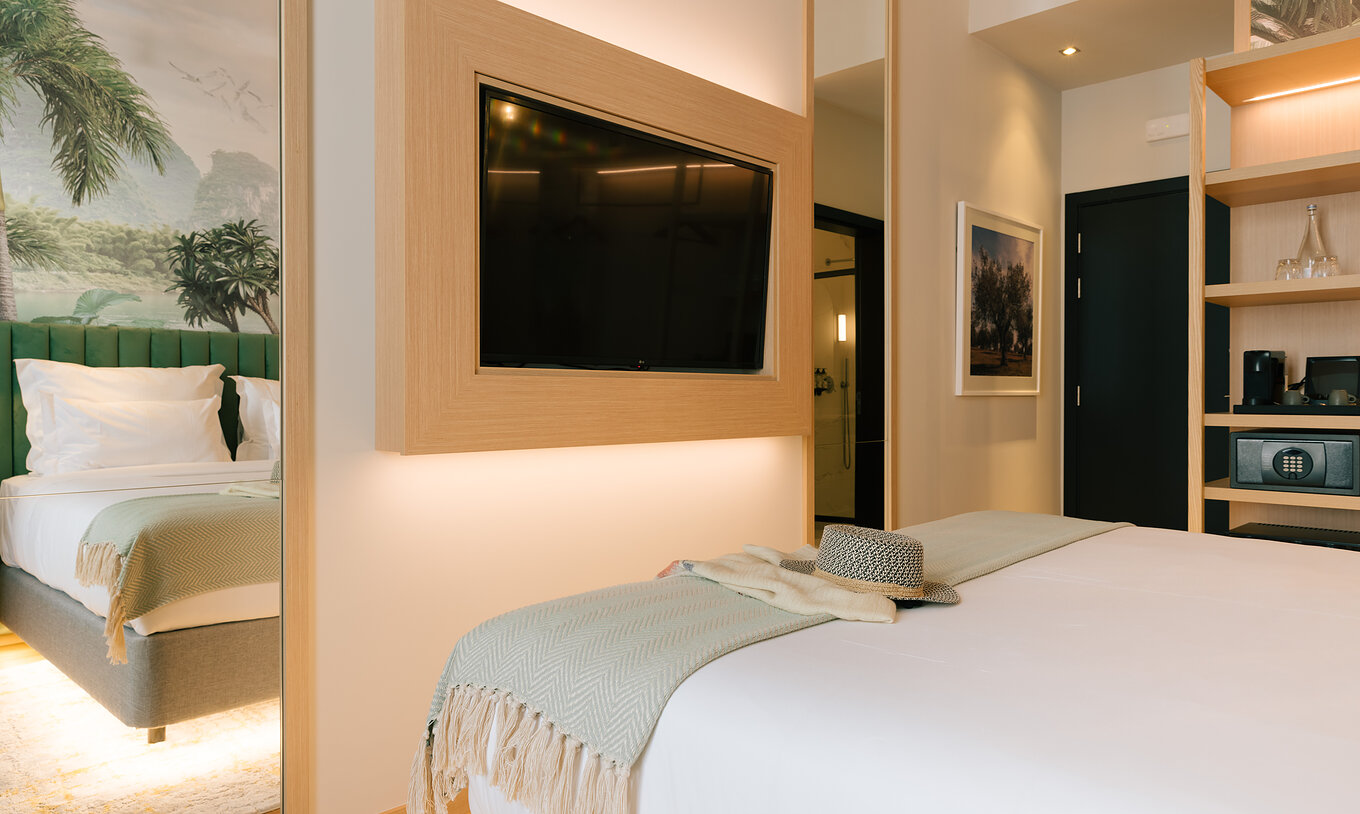 The Classic Room of Pestana Rua Augusta Lisboa has a television in front of the bed and a wardrobe with shelves and a safe