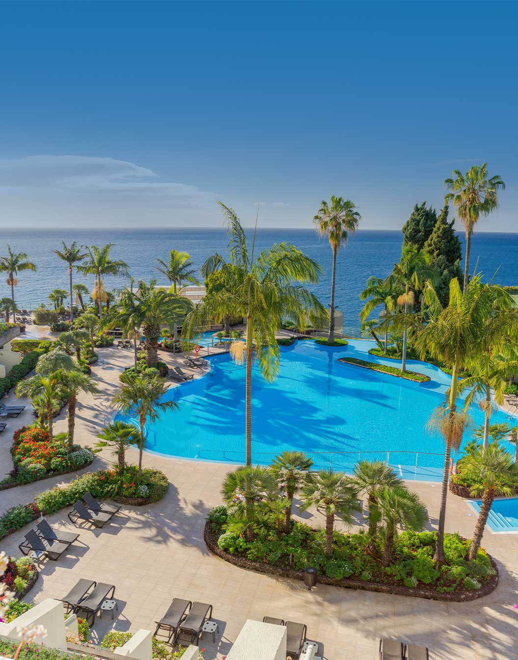 Exterior view of the pool and building of Pestana Carlton, a hotel in the center of Funchal facing the sea