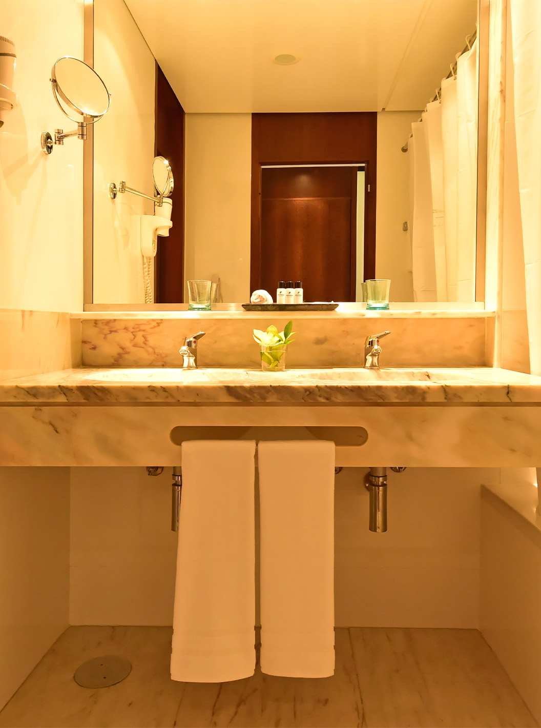 The Sea View Suite at Pestana Casino Park has a bathroom with a marble sink, bathtub, and hairdryer