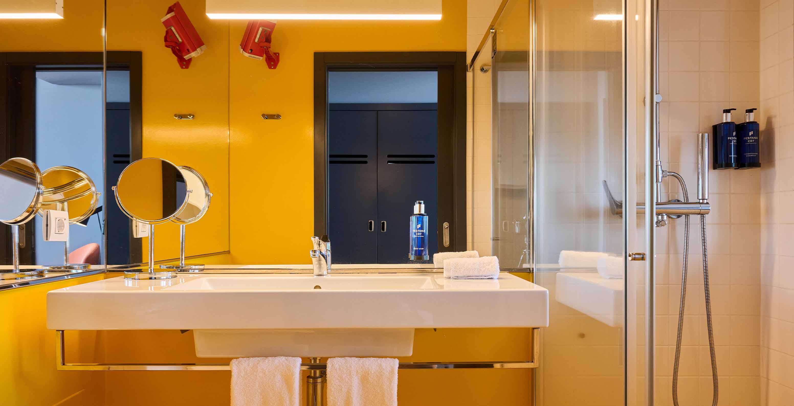The CR Superior Room at Pestana CR7 Funchal has a modern yellow bathroom equipped with a shower