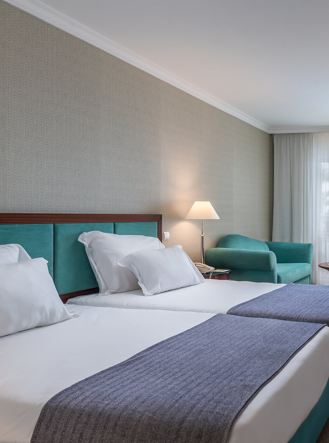 The Classic Inland View Room at Pestana Grand has two single beds, TV and an armchair