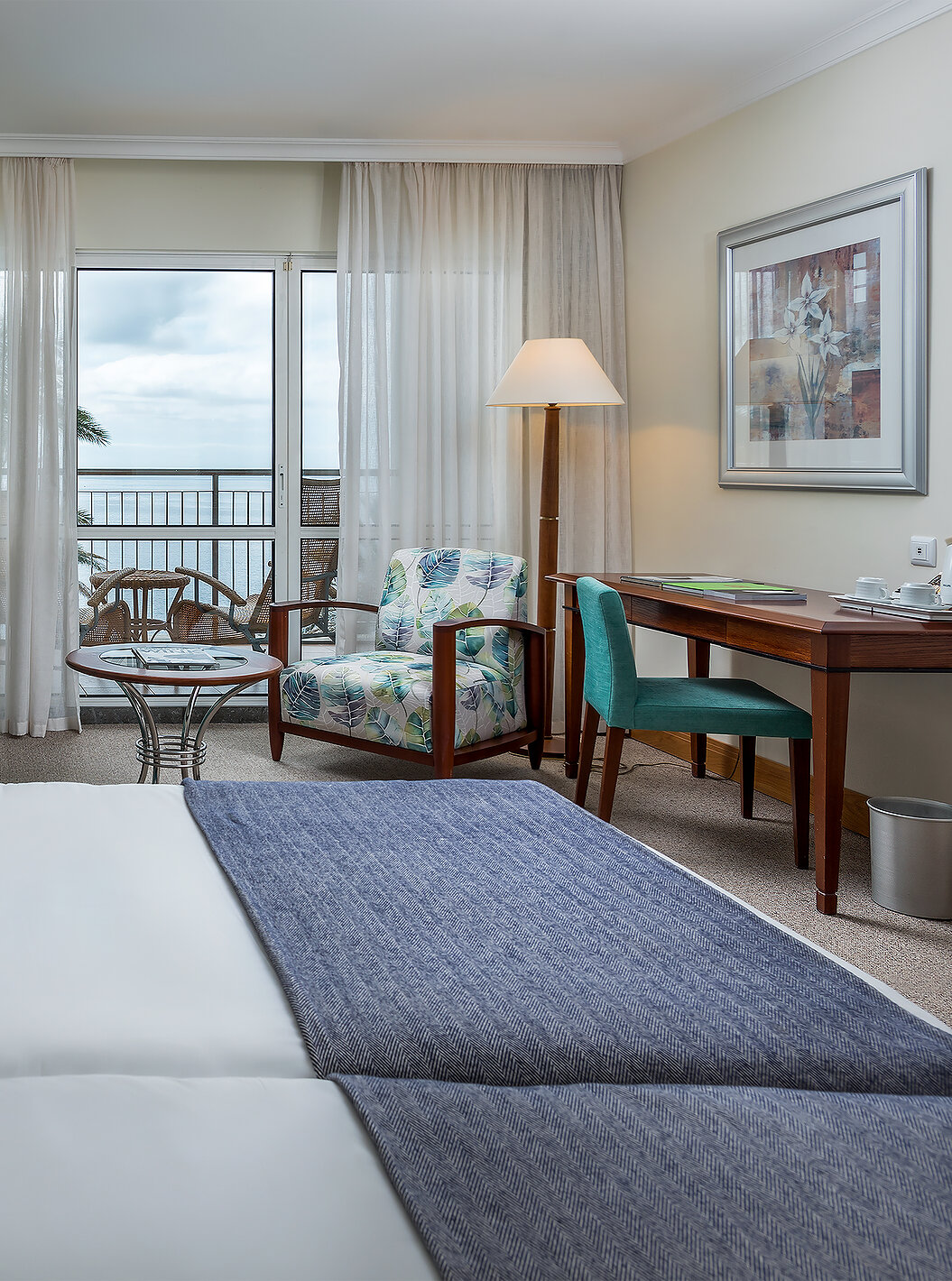 The Classic Sea View Room at Pestana Grand has two single beds, an armchair and a balcony