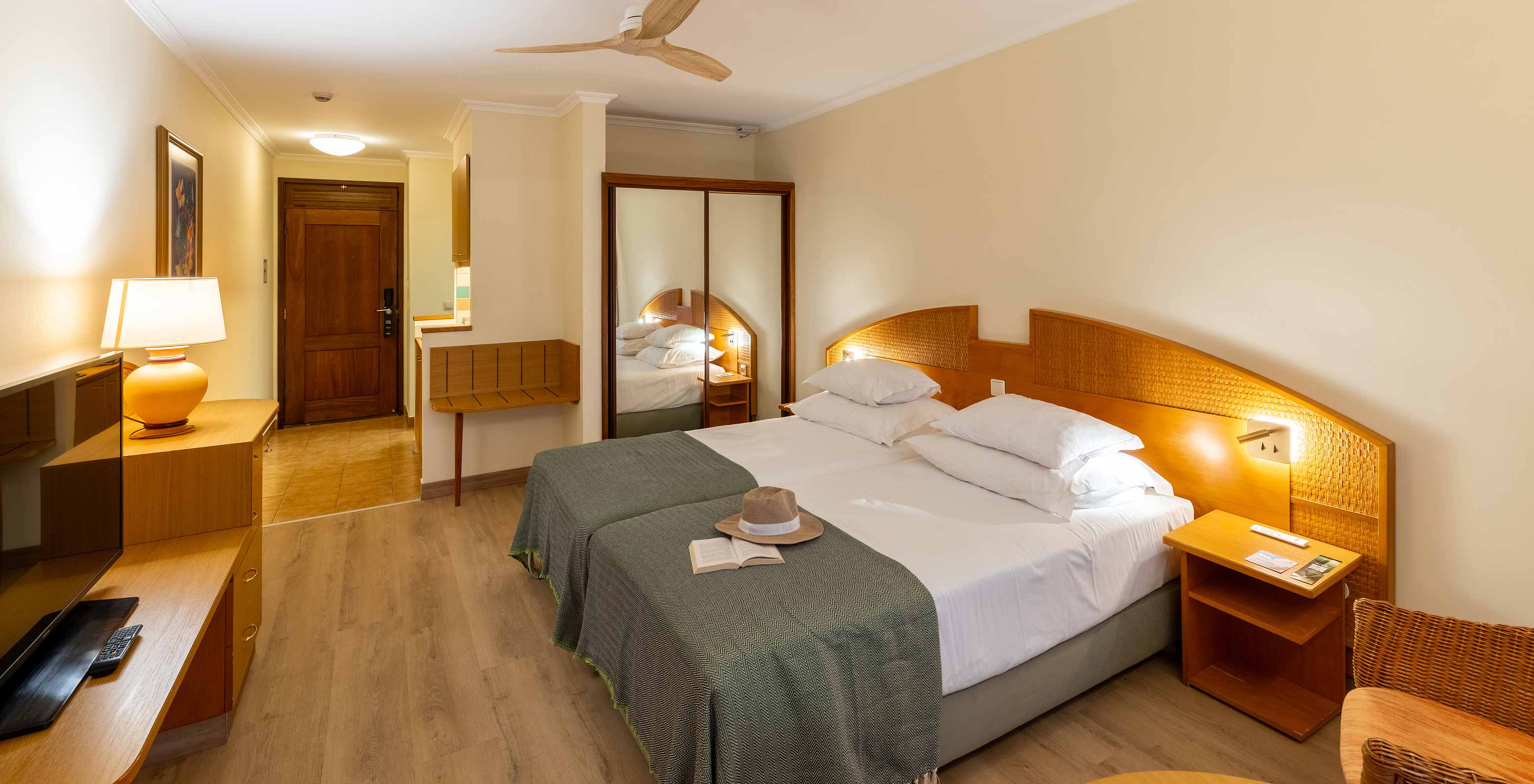 The Pestana Ocean Bay All Inclusive Classic Pool View has two single beds joined together with a green bedspread