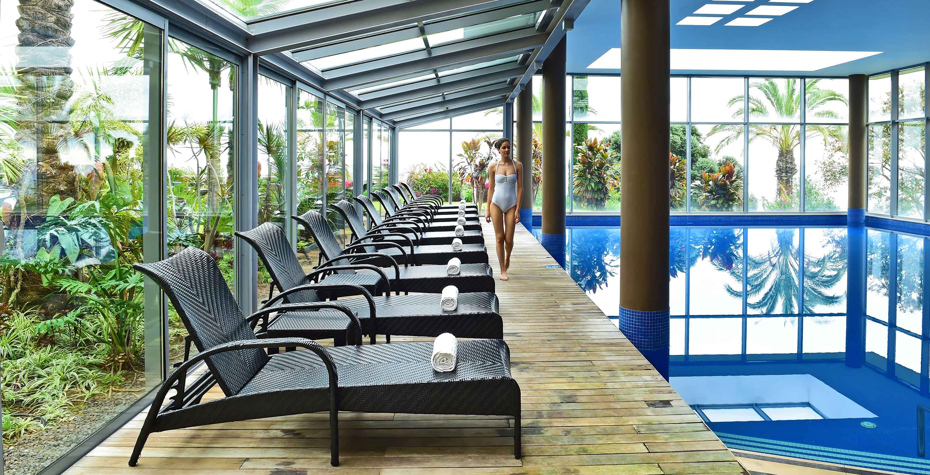 Indoor pool at Pestana Promenade, Madeira hotel near the beach and Lido, with several loungers with towels