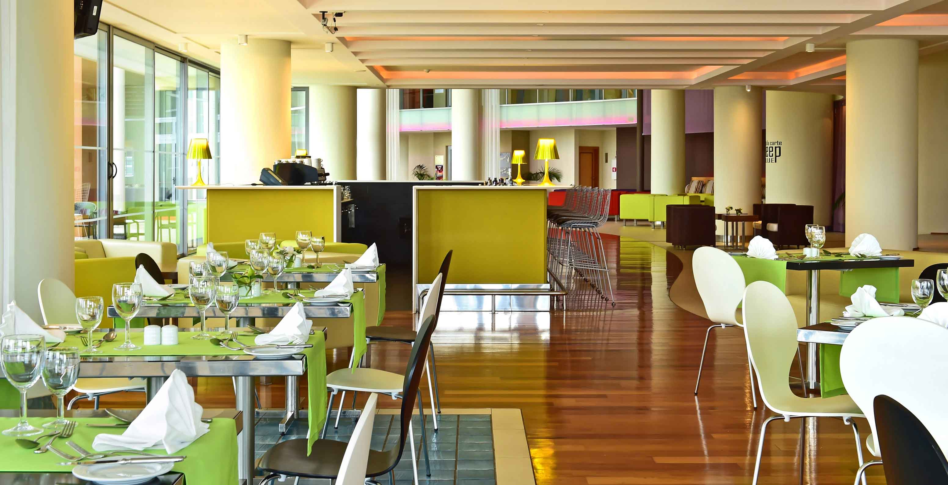 Breezes restaurant at 4-star seaside hotel in Funchal has natural light and several tables to serve meals