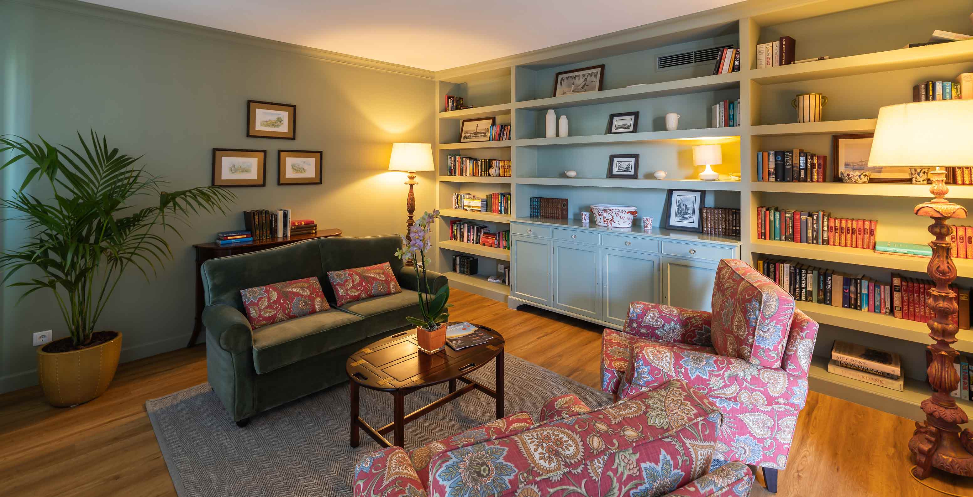 Library of Pestana Quinta Perestrello with a sofa, bookshelf, plant, and floor lamp