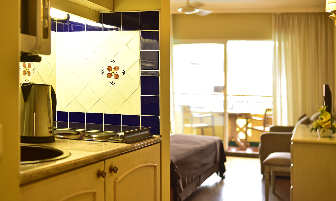 The Studio Classic at Pestana Village has a kitchen with stove burners and kettle, with balcony and double bed