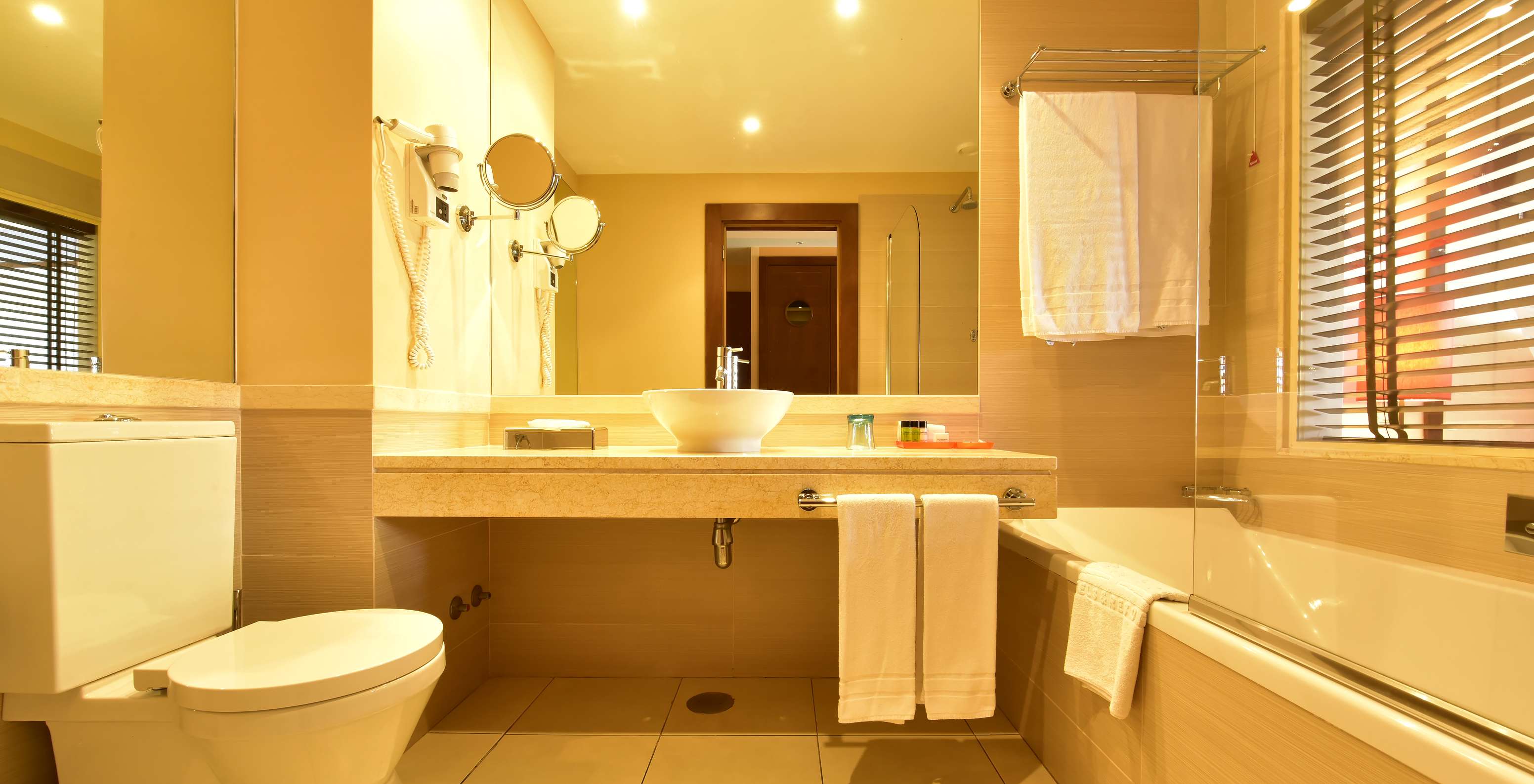 The Family Double of Pestana Porto Santo All Inclusive has a bathroom with bathtub, window, and sink with mirror