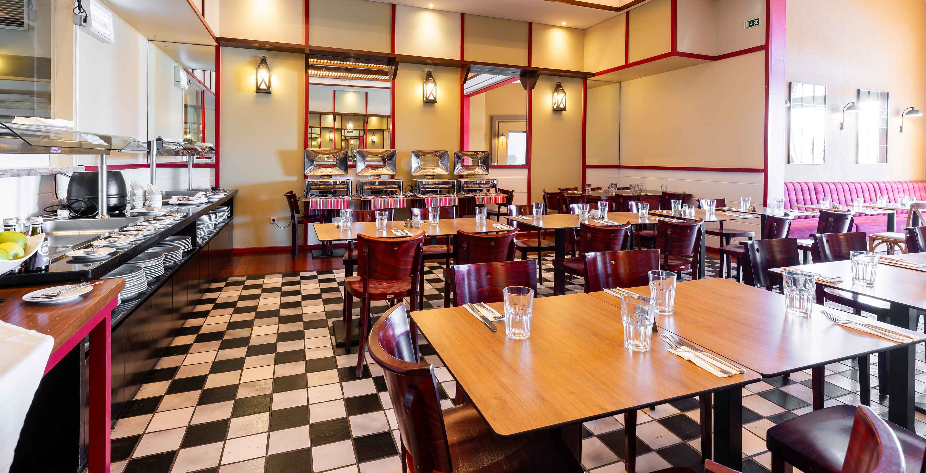 The Luigi restaurant at the 5-star Resort in Porto Santo has a floor with black and white tiles and dark chairs.