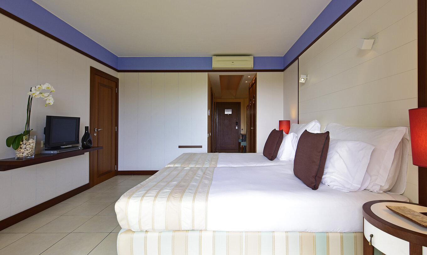 The Classic Double of Pestana Porto Santo All Inclusive has two beds, two nightstands, and a television