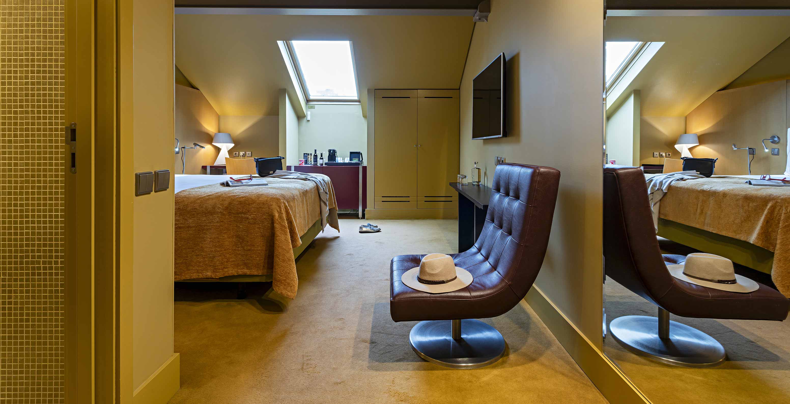 Pestana Palácio do Freixo’s Classic Attic has a double bed, a wardrobe, and a leather armchair
