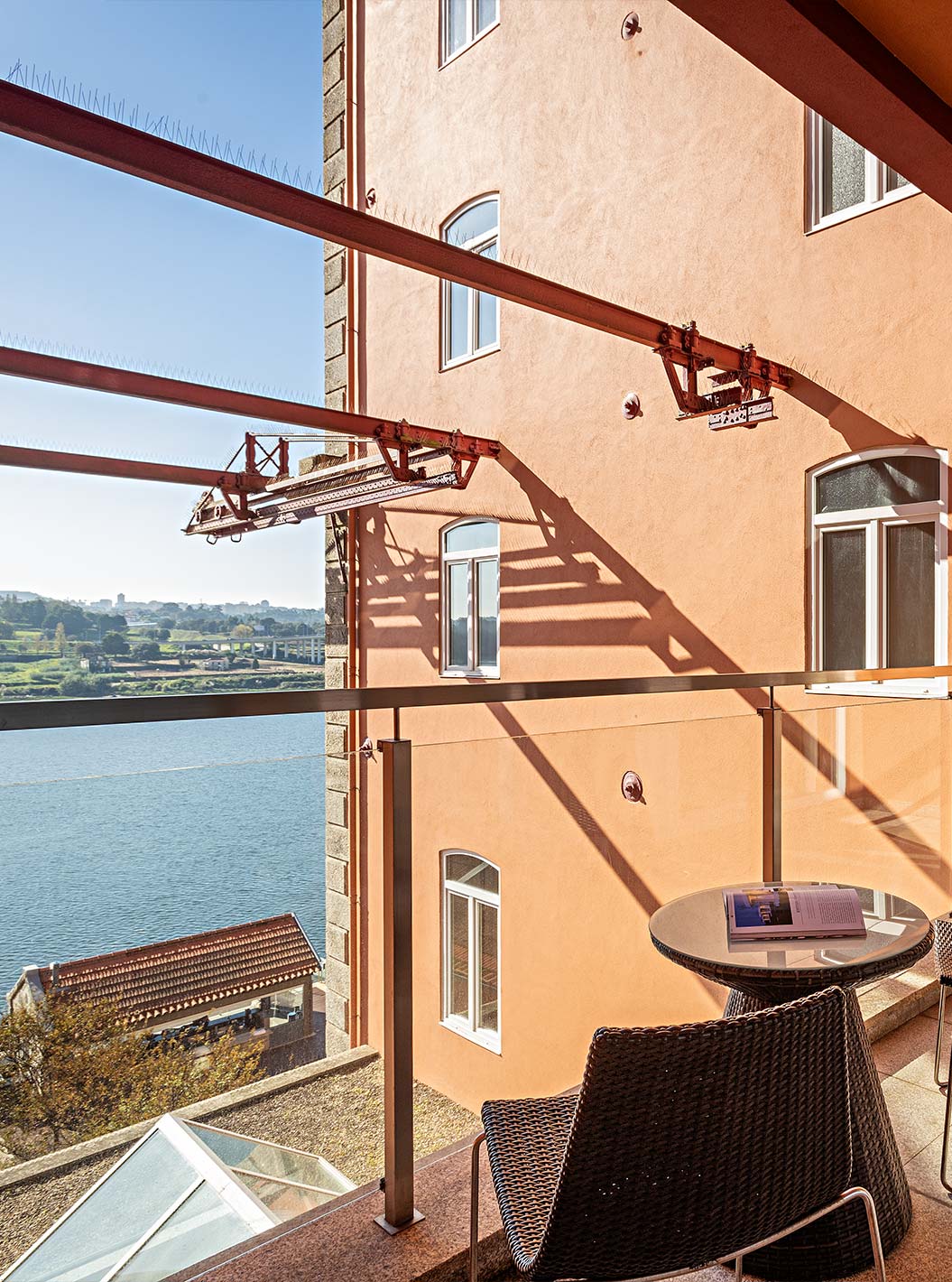 The Suite Balcony has a balcony with a table, two chairs, and a view of the Douro River