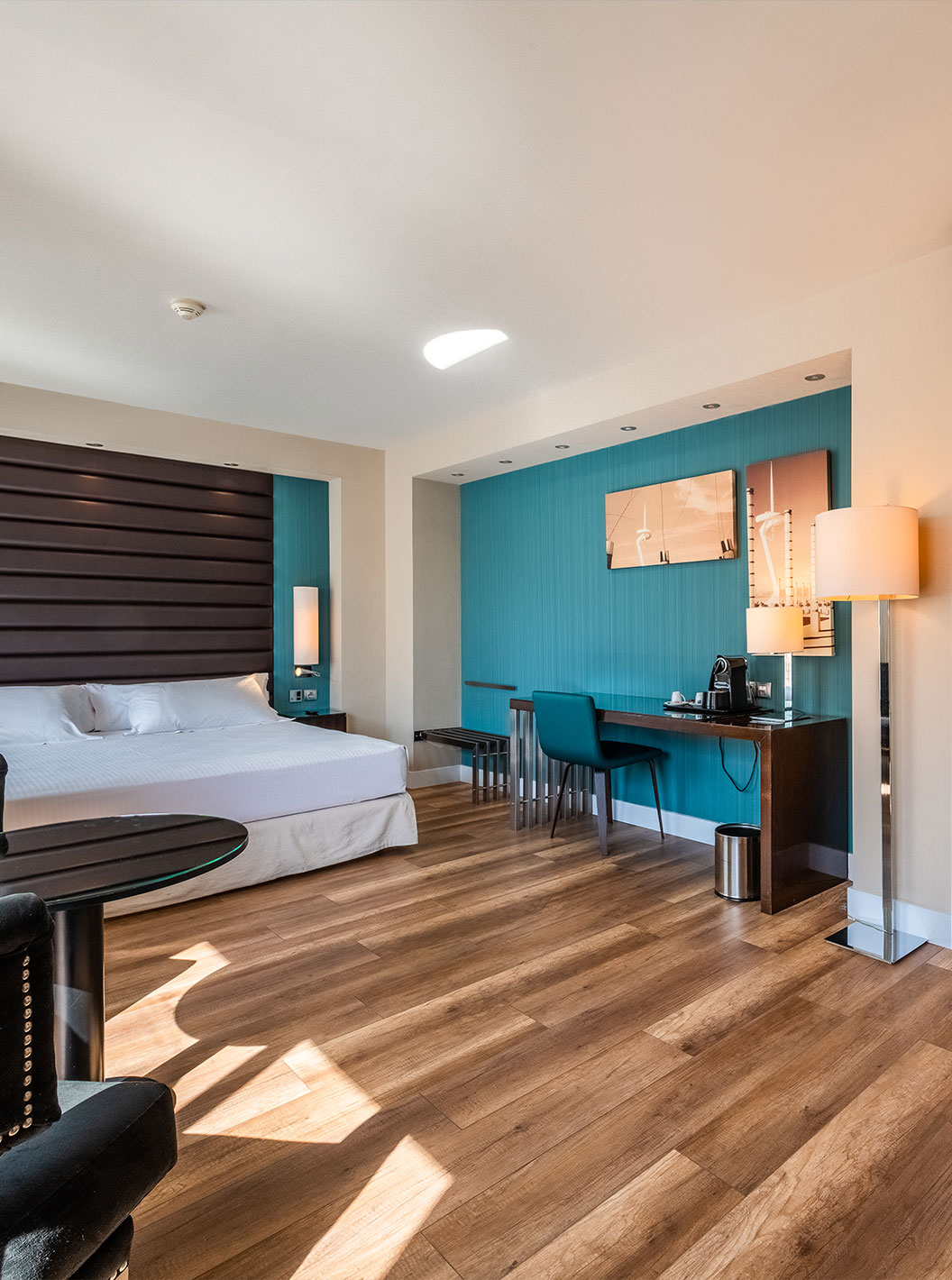 Junior Suite at Pestana Arena Barcelona has a spacious room with a TV in front of the sofa and a double bed