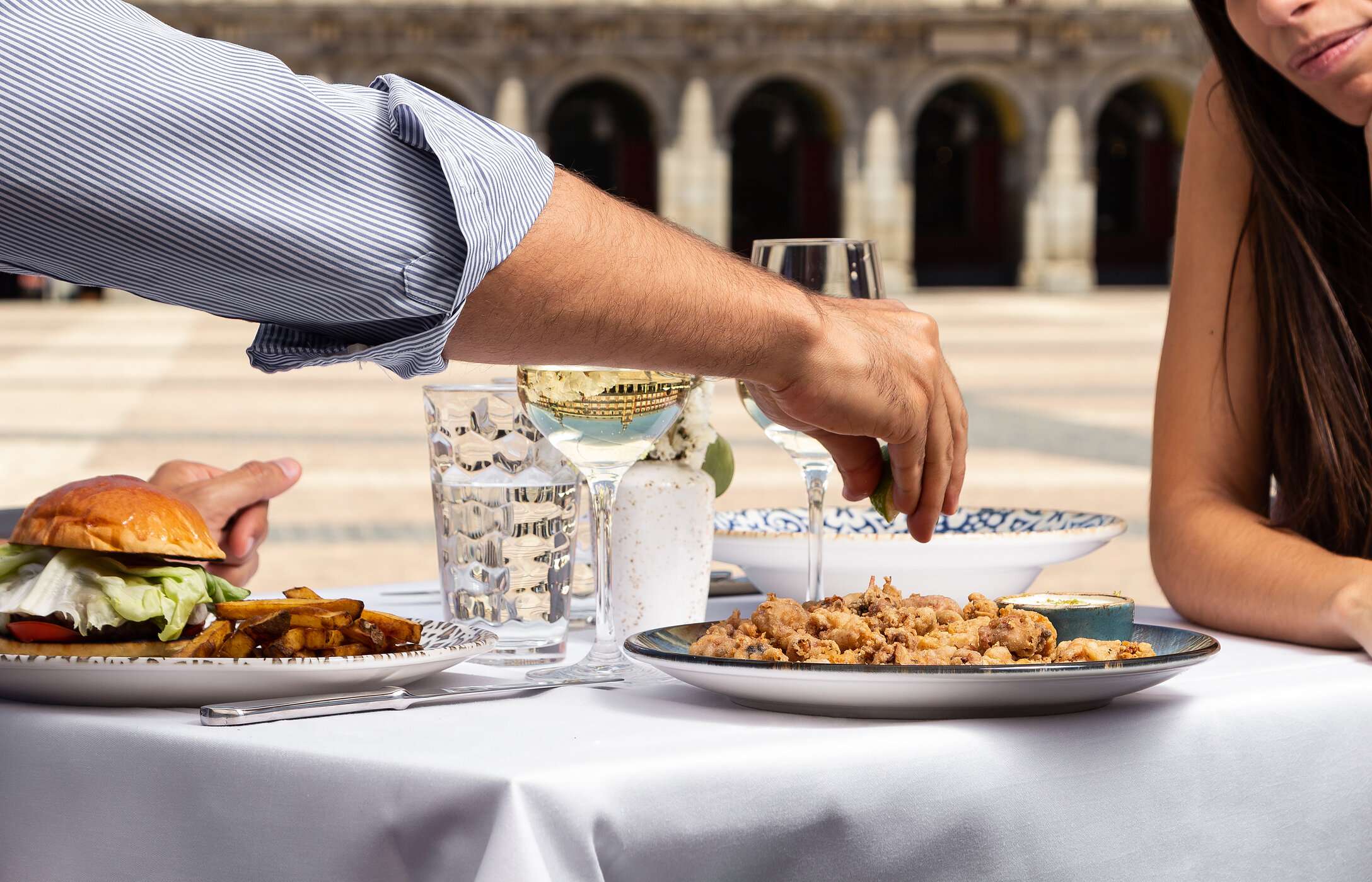 Table at a restaurant, on the terrace, at Plaza Mayor in the center of Madrid with two served dishes and two glasses of wine