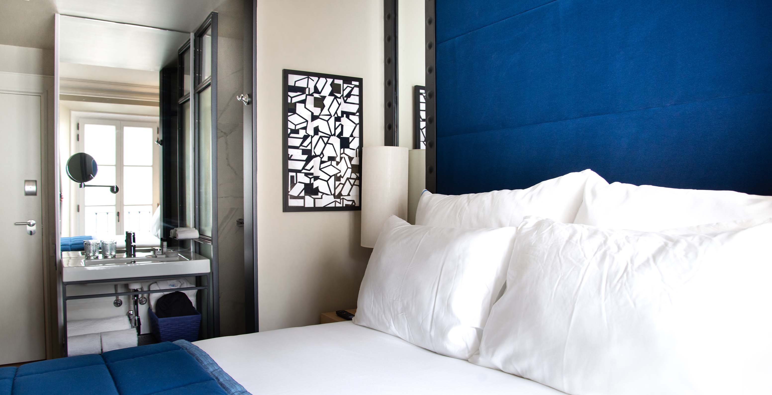 The Classic Room at Pestana Collection Plaza Mayor has a double bed, a painting and bathroom with sink