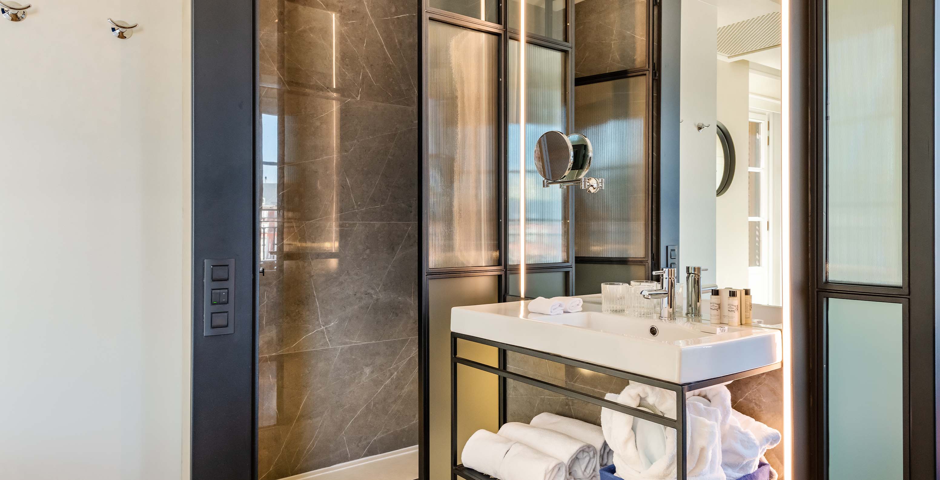 The Deluxe Plaza Mayor at Pestana Collection Plaza Mayor has a bathroom with shower, sink, mirror, towels and amenities